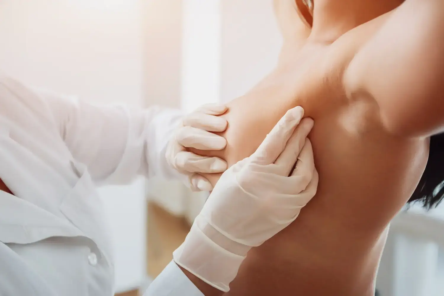Frauenarztpraxis-Faur - Gynäkologie und Geburtshilfe - Eine medizinische Fachkraft mit Handschuhen führt eine körperliche Untersuchung des Oberkörpers eines Patienten durch.