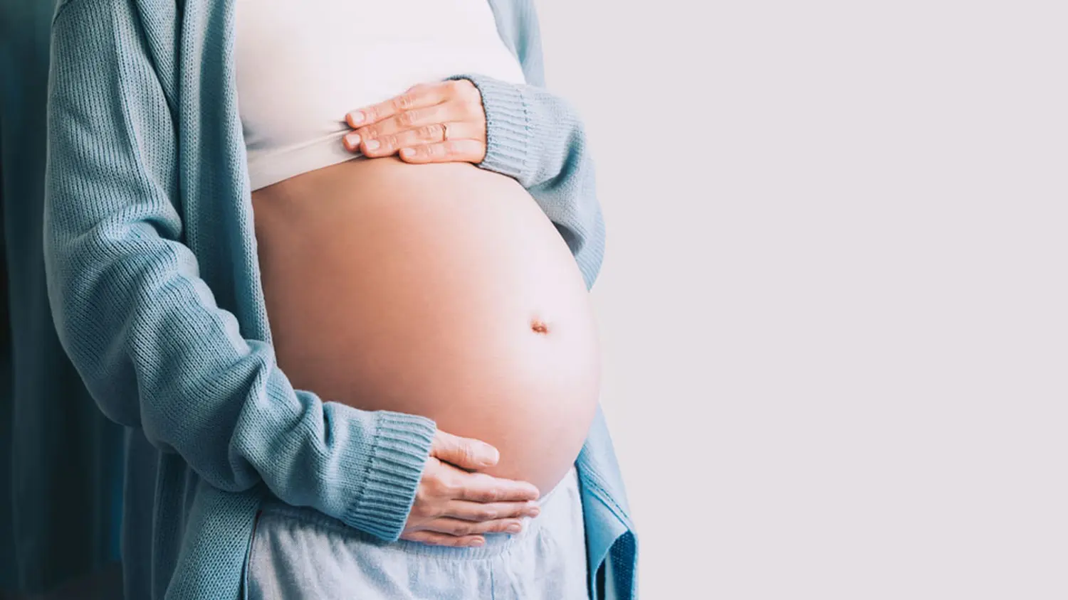 Frauenarztpraxis-Faur - Gynäkologie und Geburtshilfe - Schwangere Frau hält ihren Babybauch.
