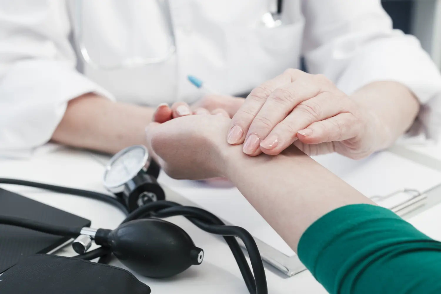 Frauenarztpraxis-Faur - Gynäkologie und Geburtshilfe - Ein Arzt im weißen Kittel überprüft in einer Klinik den Puls eines Patienten am Handgelenk.